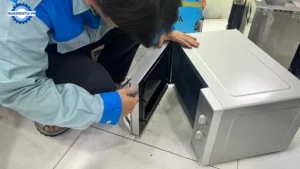 Kỹ thuật viên tiến hành tháo lắp và kiểm tra lò vi sóng